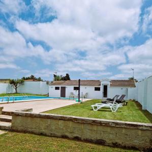 a villa with a swimming pool and a house at Pure Life Home in Chiclana de la Frontera