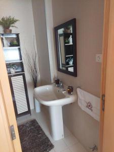 Un baño con un lavabo blanco y un espejo. en Frente barcos do mar, en Vila do Conde