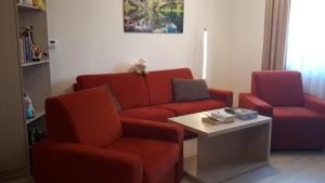 een wachtkamer met twee rode stoelen en een tafel bij Apartmán v Starej Lesnej s balkónom in Stará Lesná