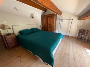 1 dormitorio con 1 cama con edredón verde en Le Castellaras - La Manonegra - Entre mer et montagne, endroit typique, nature, calme en Bézaudun-les-Alpes