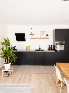 cocina con armarios negros y mesa en Exklusiv 72qm FeWo im Herzen Detmolds, Terrasse und kostenloser Parkplatz, en Detmold