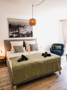 - une chambre avec un grand lit et une chaise bleue dans l'établissement Exklusiv 72qm FeWo im Herzen Detmolds, Terrasse und kostenloser Parkplatz, à Detmold