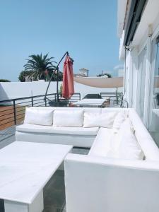 eine Reihe weißer Sofas auf dem Balkon in der Unterkunft Torreguadiaro Villa - 2 mins walk from the bars and restaurants in San Roque