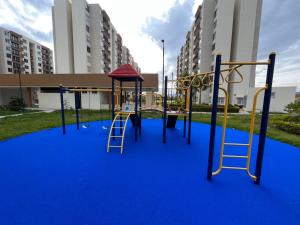 a playground with a slide and a ladder on a blue carpet at Peñalisa Club House in Ricaurte