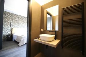 ein Bad mit einem Waschbecken, einem Spiegel und einem Bett in der Unterkunft Le Cupole Design in Palermo