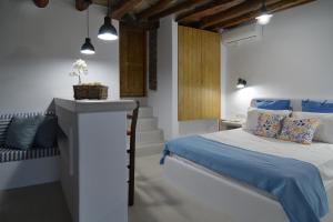 sypialnia z niebiesko-białym łóżkiem i ławką w obiekcie K vineyard house w mieście Apróvaton