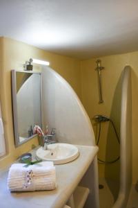W łazience znajduje się umywalka, lustro i prysznic. w obiekcie K vineyard house w mieście Apróvaton