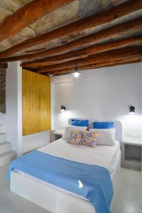 a bedroom with a large white bed with blue sheets at K vineyard house in Apróvaton