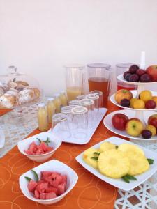 un tavolo con piatti di frutta e bicchieri di succo di Orange Paradise b&b a Custonaci