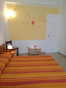 una camera da letto con un grande letto con copriletto a righe arancioni di Orange Paradise b&b a Custonaci