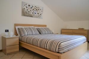 1 dormitorio con 1 cama con marco de madera en HOME 2020: COME A CASA! FEEL AT HOME! WIE ZUHAUSE!, en Giussano