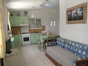ein Wohnzimmer mit Couch und eine Küche mit grünen Schränken in der Unterkunft Villa amygdalia in Kefalonia