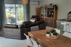 a living room with a couch and a table at BASSIN D'ARCACHON, Maison vacances climatisée au calme, proche plage in Lanton