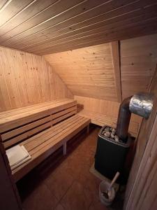 una sauna de madera con un banco y un cubo de basura en Ubytovanie v Rabčiciach, 
