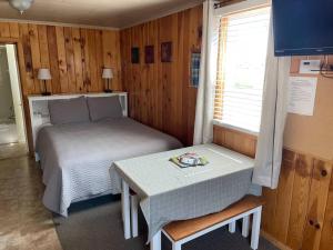 サウス・フォークにあるCozy cabin #3 at Aspen Ridge Cabinsのベッドとテーブルのある小さな寝室