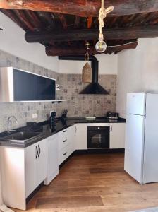 cocina con armarios blancos y nevera blanca en Casa de las Nieves en Pitres