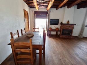 a dining room with a table and a fireplace at Casa de las Nieves in Pitres