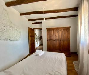 a bedroom with a white bed and a wooden ceiling at Casa de las Nieves in Pitres