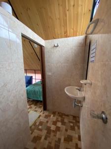a bathroom with a sink and a room with a bed at Hospedaje Villa Rosita Suesca in Suesca
