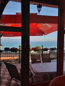 een patio met een tafel en stoelen en uitzicht op de oceaan bij Villa Gjorgi in Ohrid