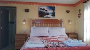 a bedroom with a bed with two towels on it at LA KANTUTA in Comunidad Yumani