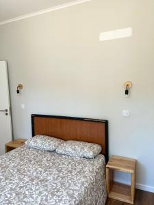 a bedroom with a bed and a white wall at Kali Vice Surf Villa in Costa da Caparica