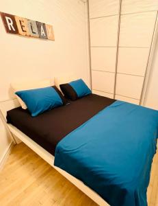 a bedroom with a bed with blue and black sheets at Boutique apartman Dora Yung in Budva