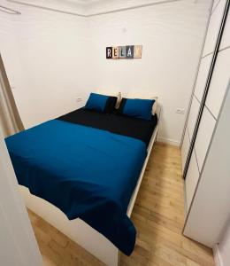 a bedroom with a bed with blue sheets and blue pillows at Boutique apartman Dora Yung in Budva