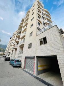 a large building with a parking garage in front of it at Boutique apartman Dora Yung in Budva