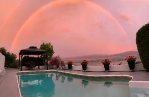 a pool with a double rainbow in the background at Bella Luna Bed and Breakfast in West Kelowna