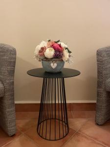 un jarrón de flores en una mesa junto a dos sillas en Penzion Elzet, en Třeboň