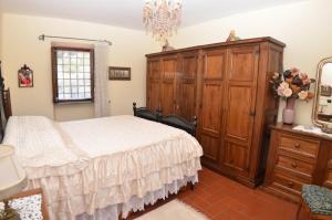 1 dormitorio con 1 cama y armario de madera en Petra, en Nievole