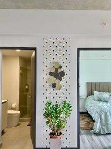 a bedroom with a bed and a bathroom with a plant at Cómodo y elegante apartamento en fabuloso condo! in San José