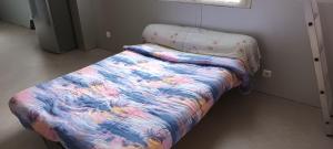 - un lit avec une couette colorée dans l'établissement Le paysage - Le studio PMR, à Arsac-en-Velay