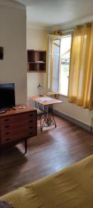 uma sala de estar com uma mesa e uma secretária em Loches : gîte de charme indépendant avec jardin em Loches