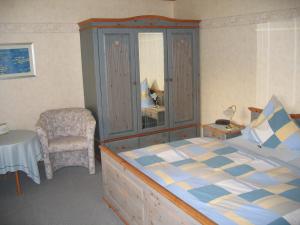 a bedroom with a bed and a table and a chair at Ferienwohnungen Hasenpatt in Bad Sachsa