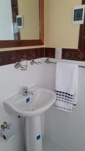 Baño blanco con lavabo y espejo en LA KANTUTA, en Comunidad Yumani