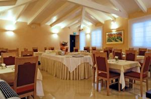 - un restaurant avec des tables et des chaises dans une salle dans l'établissement Hotel Palazzo Giancola, à San Severo