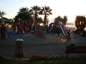 a park with a playground with slides and palm trees at Apartment on the Croisette with sea view in Cannes