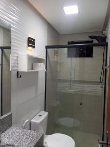 ein Bad mit einem WC und einer Glasdusche in der Unterkunft CASA CONFORTÁVEL COM 4 QUARTOS EM ALTER DO CHÃO in Alter do Chao