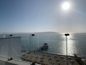 a view of the ocean with a pier and chairs at Suite 1ra Fila Vista Bahía - 70 Metros Las Velas 601 T1 in Paracas