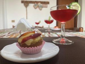 een cupcake op een bord naast een glas wijn bij Le stanze della villa in Sambuca di Sicilia