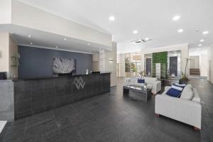 a living room with a couch and a table at Macquarie Waters Boutique Apartment Hotel in Port Macquarie