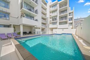 uma piscina em frente a um edifício de apartamentos em Macquarie Waters Boutique Apartment Hotel em Port Macquarie