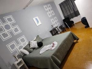 a bedroom with a bed with a green blanket at Hotel Nobre Requinte in Arujá