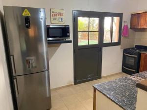 una cucina con frigorifero in acciaio inox e forno a microonde di Casa - del TALAMPAYA a Villa Unión