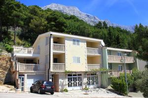 um edifício com um carro estacionado em frente em Apartment Baska Voda 10027c em Baska Voda