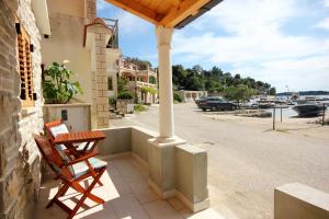 a porch with a table and chairs on a street at Seaside holiday house Grscica, Korcula - 10059 in Prizba +9 photos