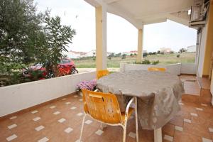 - une table et des chaises sur une terrasse couverte avec une voiture dans l'établissement Apartments with a parking space Povljana, Pag - 9405, à Povljana