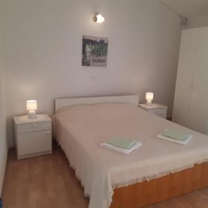 a bedroom with a white bed with two night stands at Apartment Igrane 10033a in Igrane